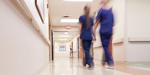 healthcare workers walking along a hospital corridor